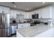 Modern kitchen with white cabinets, stainless steel appliances, and granite countertops at 1708 Hope Dr, Ormond Beach, FL 32174