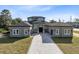 Two-story house with a gray exterior, a three-car garage, and a paver driveway at 20344 Sheldon St, Orlando, FL 32833