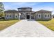 Two-story house with a gray exterior, a three-car garage, and a paver driveway at 20344 Sheldon St, Orlando, FL 32833
