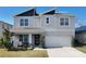 Two-story house with gray siding, dark gray roof accents, and a two-car garage at 236 Talisi Loop, St Cloud, FL 34771