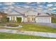Two-story home with gray siding, three-car garage, and landscaped front yard at 2423 Hyatt Creek Ln, Port Orange, FL 32128