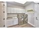 Bright laundry room with washer, dryer, and ample cabinetry at 2423 Hyatt Creek Ln, Port Orange, FL 32128