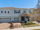 Two-story townhome with gray siding, stone accents, and a two-car garage at 2741 Pleasant Cypress Cir, Kissimmee, FL 34741