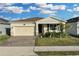 House exterior featuring a two-car garage and well-manicured lawn at 3087 Camden Way, Davenport, FL 33837
