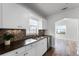 Updated kitchen with white cabinets and a mosaic backsplash at 3303 Helen Ave, Orlando, FL 32804