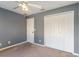 Bedroom with ceiling fan, gray walls, and double closet at 34514 S Haines Creek Rd, Leesburg, FL 34788