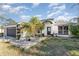 Single-story home with palm tree, landscaping, and driveway at 34514 S Haines Creek Rd, Leesburg, FL 34788