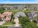 An aerial view showing the lake behind the house, as well as the landscaping and trees at 408 Chelsea Ave, Davenport, FL 33837