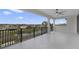 Spacious balcony with tiled flooring, ceiling fan, and iron railings overlooking a tranquil pond at 408 Chelsea Ave, Davenport, FL 33837