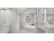 A luxurious bathroom featuring a soaking tub, marble floors, arched windows and decorative columns at 408 Chelsea Ave, Davenport, FL 33837