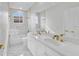 Modern bathroom with double vanity, white marble countertops, and glass enclosed shower and tub at 408 Chelsea Ave, Davenport, FL 33837