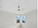 Bright bedroom features dual windows, ceiling fan, and neutral decor at 408 Chelsea Ave, Davenport, FL 33837