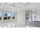 A light filled bedroom with tray ceilings, large windows, a ceiling fan, and sliding doors to the patio at 408 Chelsea Ave, Davenport, FL 33837