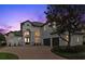 Elegant two-story home boasts a brick driveway and lush landscaping at 408 Chelsea Ave, Davenport, FL 33837