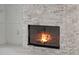 Close up of a stone fireplace with a burning fire at 408 Chelsea Ave, Davenport, FL 33837