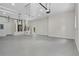 Spacious, well lit garage with epoxy floors and white walls features a side door and garage door with opener at 408 Chelsea Ave, Davenport, FL 33837