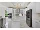 Bright kitchen features white cabinetry, stainless steel appliances, and a center island with stone countertops at 408 Chelsea Ave, Davenport, FL 33837