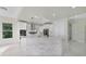 A modern kitchen with stainless steel appliances, white cabinets, stone countertops, and a center island at 408 Chelsea Ave, Davenport, FL 33837