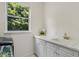 Bright laundry room featuring white cabinetry, quartz countertop, and undermount sink beneath a window at 408 Chelsea Ave, Davenport, FL 33837