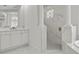 Elegant main bathroom featuring white marble tile, vanity, and glass enclosed shower at 408 Chelsea Ave, Davenport, FL 33837