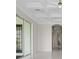 Bright main bedroom featuring white marble floors, coffered ceilings, and sliding glass doors at 408 Chelsea Ave, Davenport, FL 33837