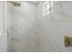 Modern shower featuring white marble tile, a glass block window, and a rain shower head at 408 Chelsea Ave, Davenport, FL 33837