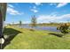 Lakefront backyard with lush grass and mature trees at 6922 Audobon Osprey Cv, Harmony, FL 34773