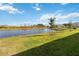 Peaceful backyard view features a pond and lush grass at 6922 Audobon Osprey Cv, Harmony, FL 34773
