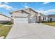 Two-story house with a three-car garage and landscaped yard at 6922 Audobon Osprey Cv, Harmony, FL 34773