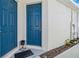 House exterior featuring two blue doors and a welcome mat at 6922 Audobon Osprey Cv, Harmony, FL 34773