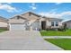 Two-story house with a three-car garage and landscaped yard at 6922 Audobon Osprey Cv, Harmony, FL 34773
