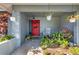 Inviting front porch with red door, rocking chair, and potted plants at 8134 Hook Cir, Orlando, FL 32836