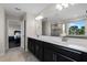 Double vanity bathroom with large mirror, walk-in shower, and view of backyard at 8729 Eden Cove Dr, Winter Garden, FL 34787
