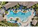 Aerial shot of the community pool showcasing blue lounge chairs, palm trees, and a unique winding design at 8729 Eden Cove Dr, Winter Garden, FL 34787