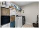 Bright laundry room with washer, dryer, and storage shelves at 8729 Eden Cove Dr, Winter Garden, FL 34787