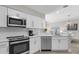 Modern white kitchen with stainless steel appliances at 8774 Worldquest Blvd, Orlando, FL 32821
