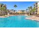 Large resort pool with palm trees and lounge chairs at 8801 Worldquest Blvd, Orlando, FL 32821