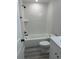 Bathroom with a shower over the tub, white subway tiles, and gray flooring at 102 Colomba Rd, Debary, FL 32713