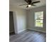 Bedroom features gray flooring, a ceiling fan, a window, and a closet with white doors at 102 Colomba Rd, Debary, FL 32713