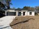 Newly constructed home with a modern design, featuring a gray stone facade and a black garage door at 102 Colomba Rd, Debary, FL 32713