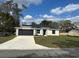 Charming one-story home featuring a dark gray two-car garage and well-maintained lawn at 102 Colomba Rd, Debary, FL 32713