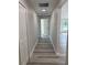 Hallway with gray laminate flooring, white trim and doors at 102 Colomba Rd, Debary, FL 32713