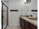 Well-lit bathroom features double vanity, framed mirror, and a tiled shower with glass door at 1074 Clifton Springs Ln, Winter Springs, FL 32708