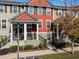 Charming townhouse with red siding, black railings, and manicured landscaping at 1074 Clifton Springs Ln, Winter Springs, FL 32708