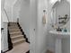 Hallway with carpeted stairs and a powder room with a pedestal sink at 1074 Clifton Springs Ln, Winter Springs, FL 32708