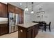 Spacious kitchen island with stainless steel refrigerator, pendant lighting, and adjacent dining area at 1074 Clifton Springs Ln, Winter Springs, FL 32708