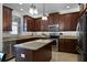 A kitchen features dark cabinetry, stainless steel appliances, and granite countertops, with pendant lighting above the island at 1074 Clifton Springs Ln, Winter Springs, FL 32708