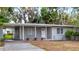 Gray single story house with carport and well-manicured lawn at 1110 Oak Dr, Leesburg, FL 34748