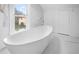 Modern bathroom featuring a white bathtub and marble wall tiles at 119 Leon Ave, Deland, FL 32720