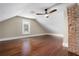 Attic bedroom with hardwood floors, exposed brick, and ceiling fan at 119 Leon Ave, Deland, FL 32720